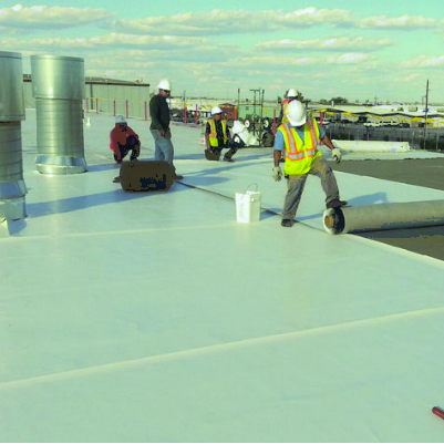 Commercial roofing crew installing TPO flat roofing system in Tampa as part of a roof replacement project