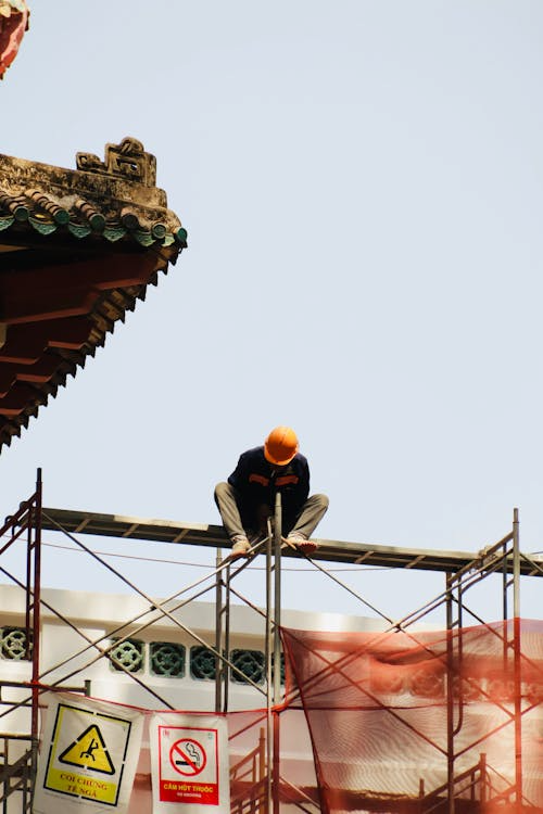 An image of a person sitting on a scaffolding