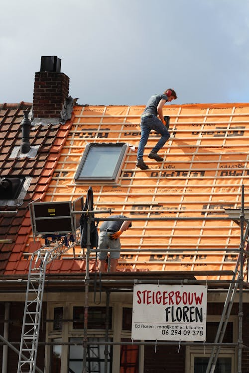 workers working on the top of a roof of an establishment