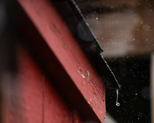Water dripping from the roof edge during a storm
