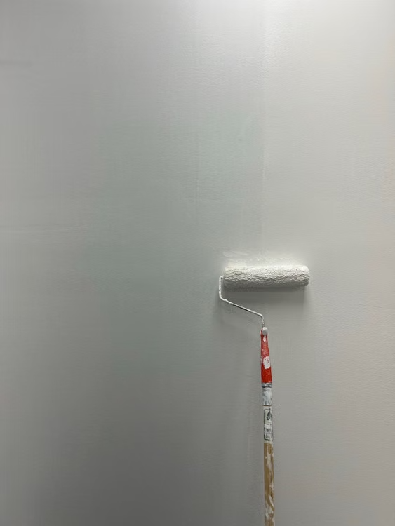 a roller applying roof coating