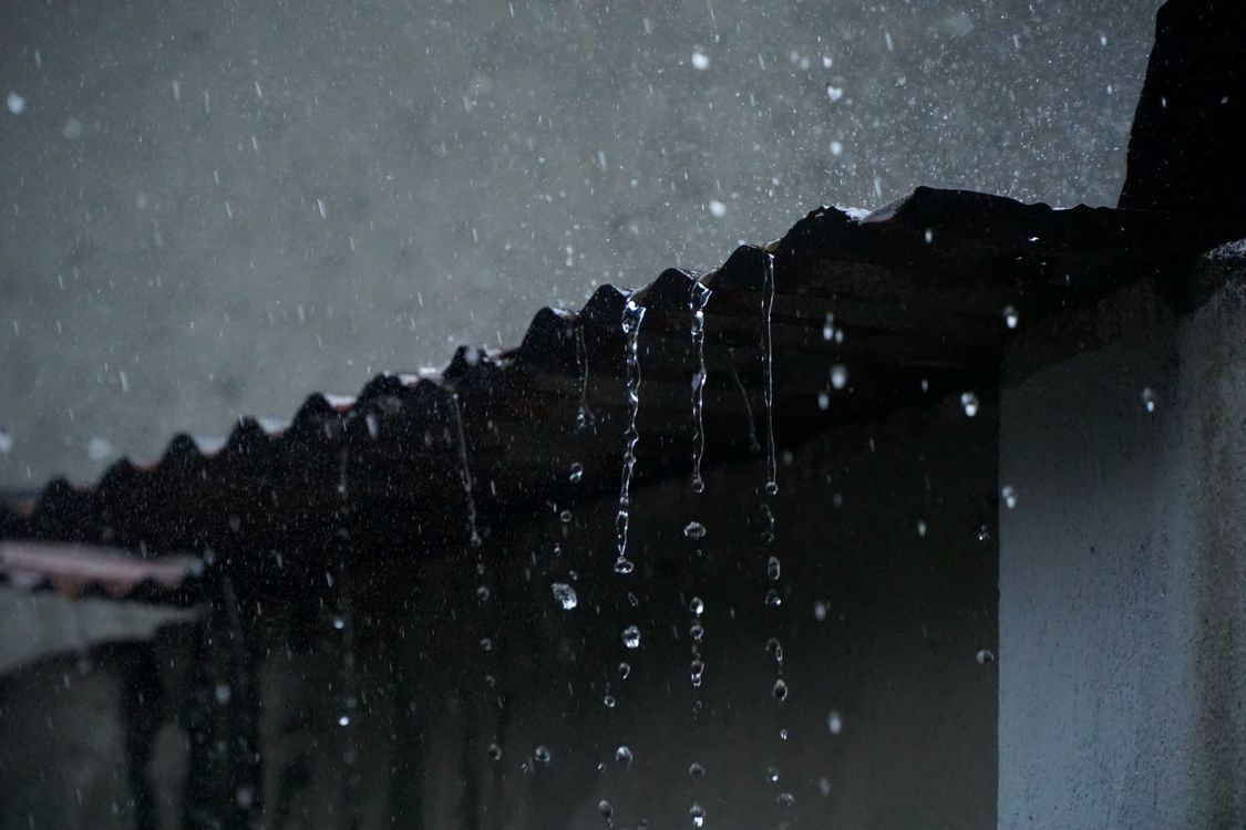 water droplets from a storm falling down a roof
