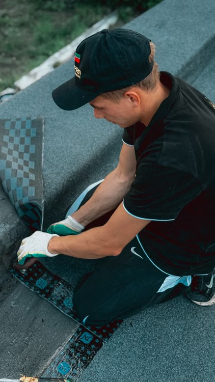 A roofer applying roofing material to a flat commercial roof.
