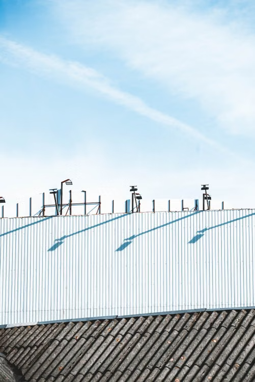 Industrial rooftop with corrugated metal under a clear blue sky.