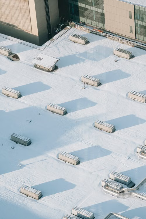 Large white PVC membrane roof covering a commercial building with rooftop equipment
