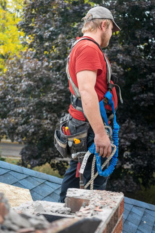 Roofing professional inspecting a low-slope commercial roof near rooftop equipment